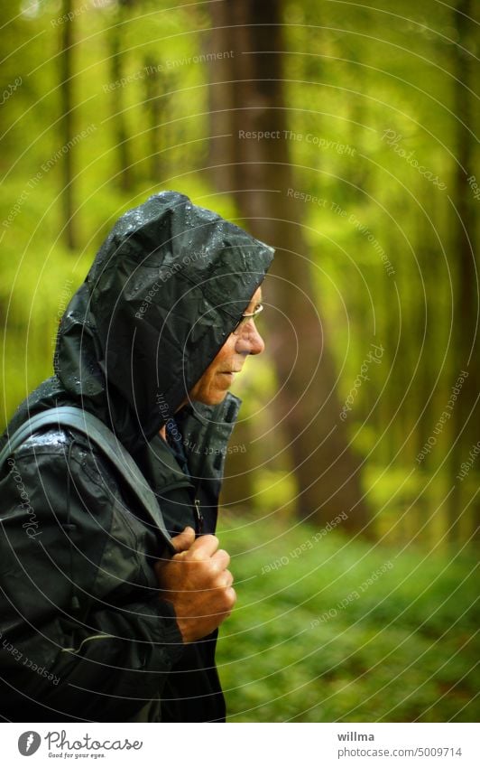 Wandern im Regen Wanderer Senior Mann Wald Regenjacke Regenbekleidung Regenwetter Kapuze nass Naturfreund schlechtes Wetter Mensch