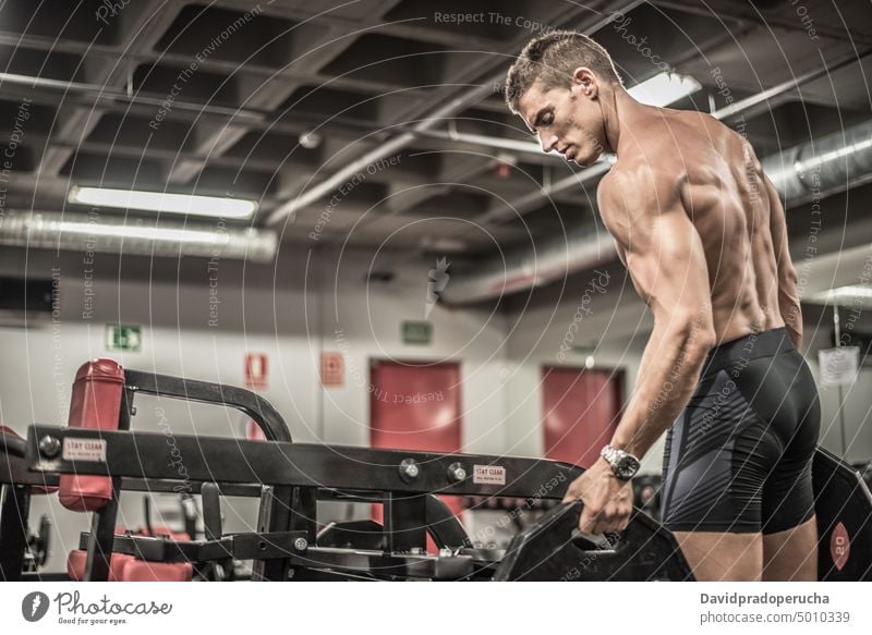 Sportler in der Turnhalle stehend Mann Fitnessstudio Langhantel muskulös passen Athlet Übung Körper Training männlich Kraft Gesundheit Muskel stark Erwachsener