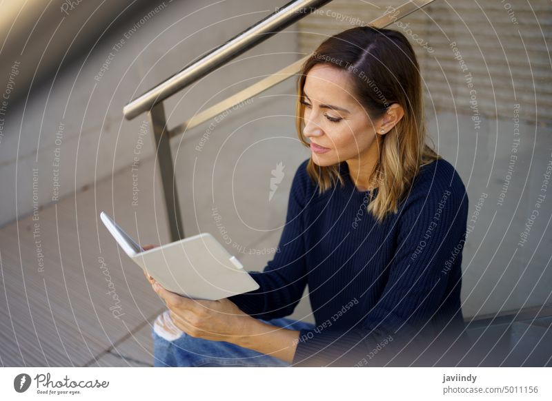 Frau mittleren Alters liest in einer Kaffeepause in der Nähe ihres Büros mit ihrem E-Book. eBook mittleres Alter Kaukasier urban Lifestyle Technik & Technologie