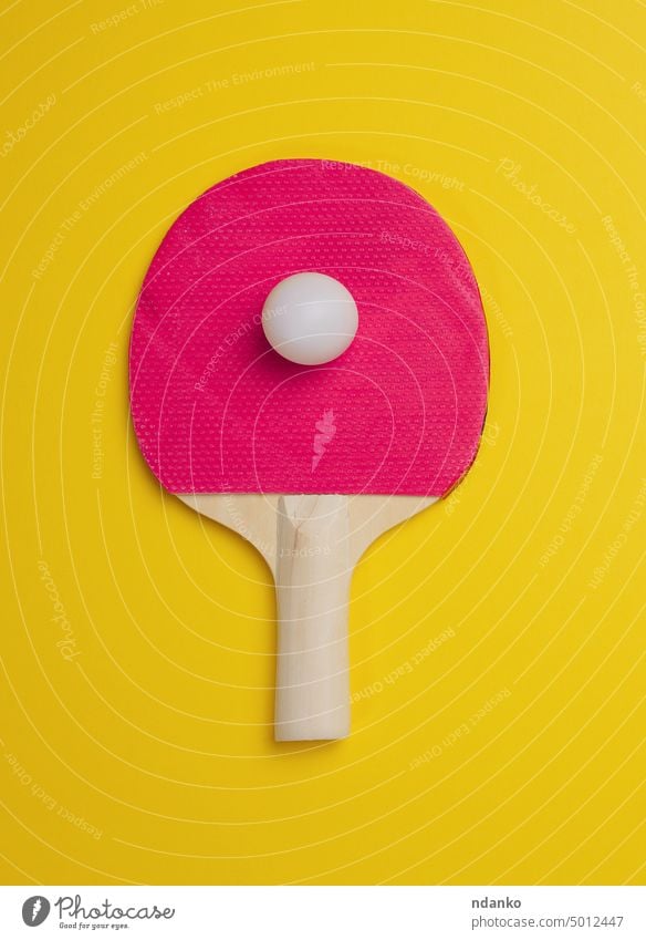Ping-Pong-Tennisschläger aus Holz und Plastikball auf gelbem Hintergrund Ball Tischtennis Sport Spiel Remmidemmi Gerät Freizeit pong wettbewerbsfähig Paddel