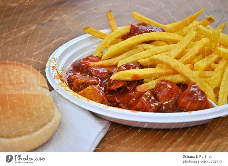 Currywurst mit Pommes und Brötchen auf einem Plastikteller Fastfood Ernährung Lebensmittel Essen lecker Snack ungesund Imbiss Pommes frites Ketchup Fett