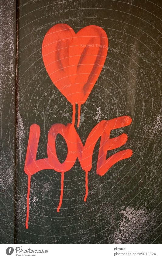 Ein rotes Herz und LOVE sind in verlaufender, knallig roter Farbe an eine schwarze Wand gemalt / Liebe love Liebeserklärung Graffiti Gefühle Verliebtheit