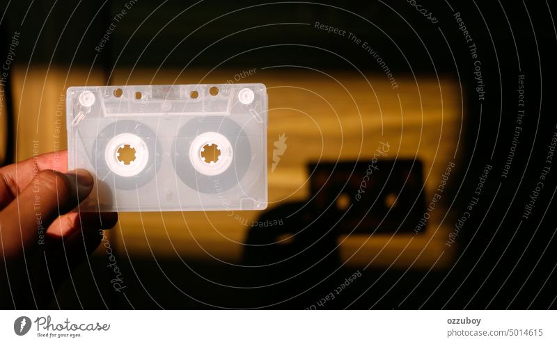 Nahaufnahme einer Hand, die ein transparentes weißes Kassettenband hält Audio Musik Klang Klebeband alt retro altehrwürdig Beteiligung Finger Halt Spieler