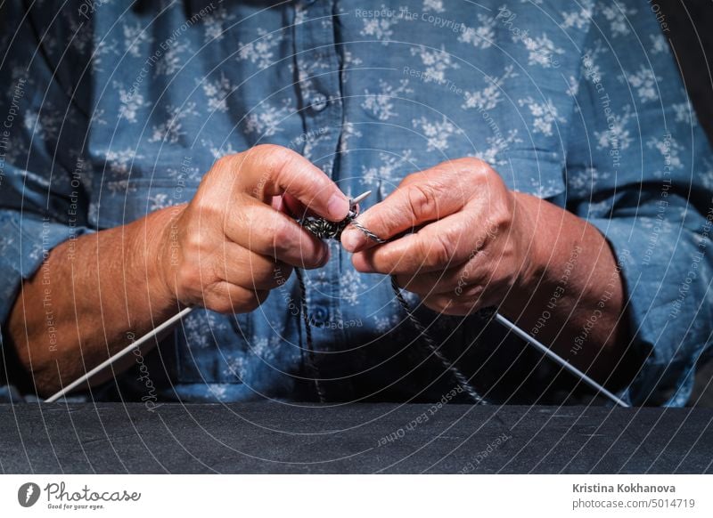 Close up Hände mit Falten der älteren Frau Stricken Wolle Garn Pullover oder Schal für den Winter. Großmutter strickt zu Hause. Prozess der Herstellung von Kleidung. Hobby Konzept.
