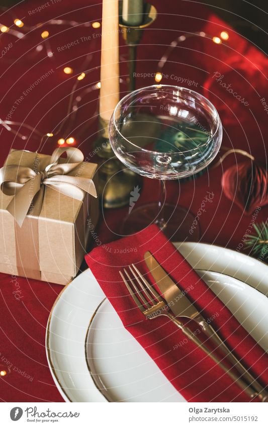 Weihnachtlich gedeckter Tisch auf rotem Tischtuch. Weihnachten Einstellung Abendessen heimwärts Geschenk Lichter elegant Kasten Tischwäsche