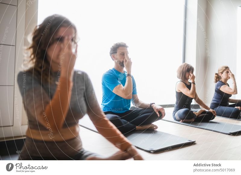 Gruppe von Menschen bei einer Atemübung während eines Yoga-Kurses Mudra üben Menschengruppe gestikulieren Wohlbefinden Wellness Gesundheit Asana Zen Lotus-Pose
