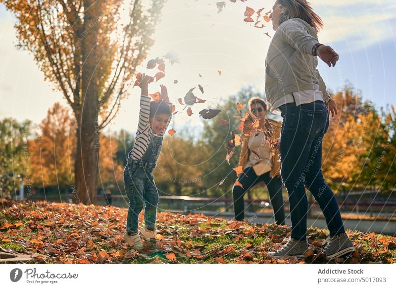 Unbekümmerte lesbische Familie mit Kind beim Spielen im Park spielen lgbt Paar Spaß haben Herbst Wochenende Homosexualität Sohn Zusammensein Glück werfen Blatt