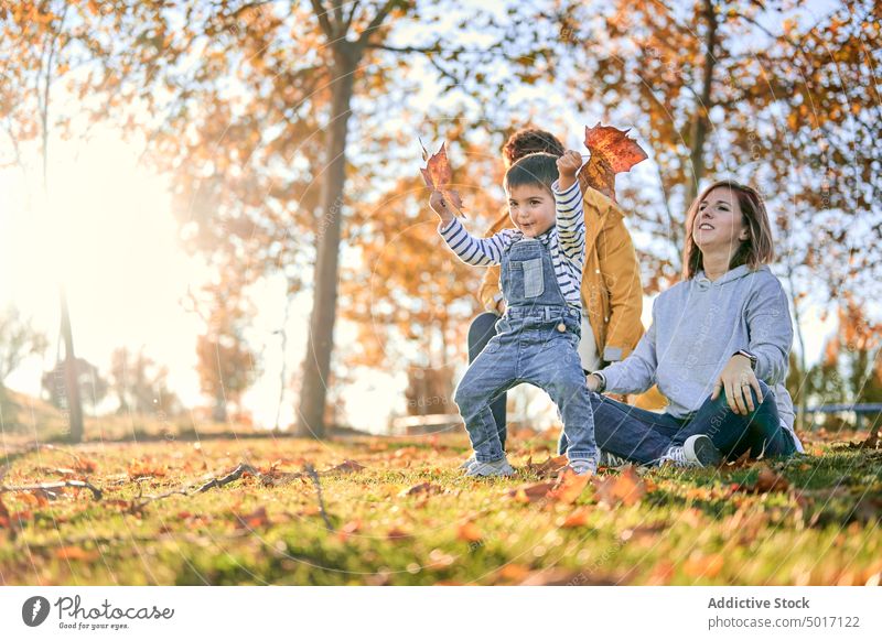Lesbische Familie mit Sohn im Herbstpark lesbisch Kind spielen Park Paar Zusammensein lgbt Spaß haben Liebe Partnerschaft Kindheit Junge Bonden Mutter Lächeln