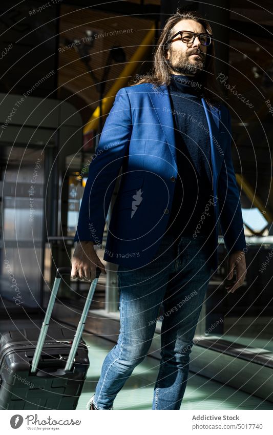 Trendy männlicher Passagier zu Fuß im Flughafen Mann trendy Stil Koffer Ausflug Business ernst Spaziergang Erwachsener selbstbewusst reisen modern Gepäck