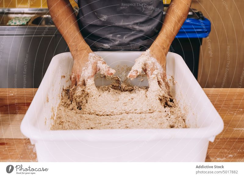 Anonymer Mann bereitet Teig in einer Bäckereiküche vor Arbeit kneten Teigwaren vorbereiten professionell Küche Prozess manuell männlich jung Arbeiter Beruf