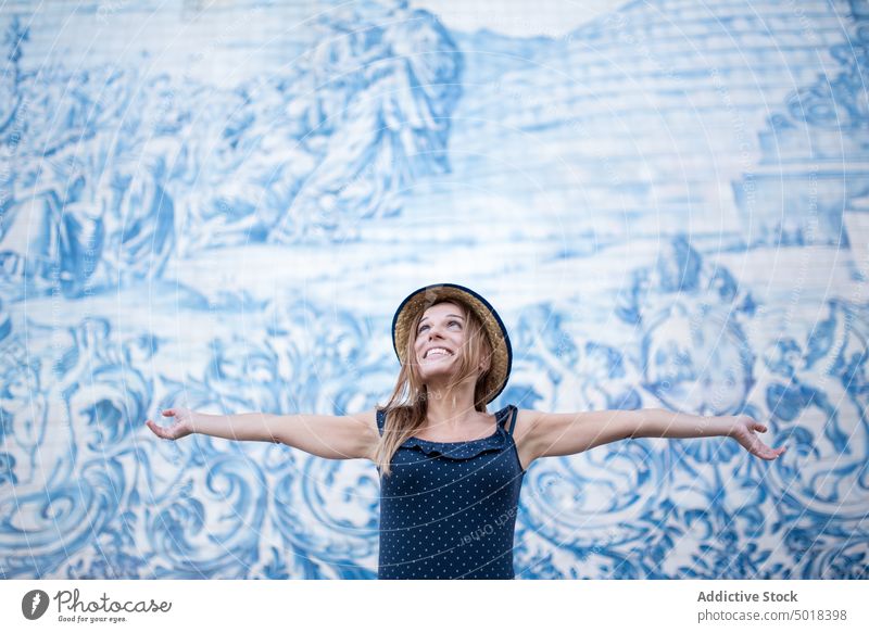 Zufriedene Touristin an der Wand mit Wandmalerei in der Stadt Reisender Fresken Kunst Freiheit froh ausdehnen genießen feminin Frau reisen alt Lächeln Inhalt