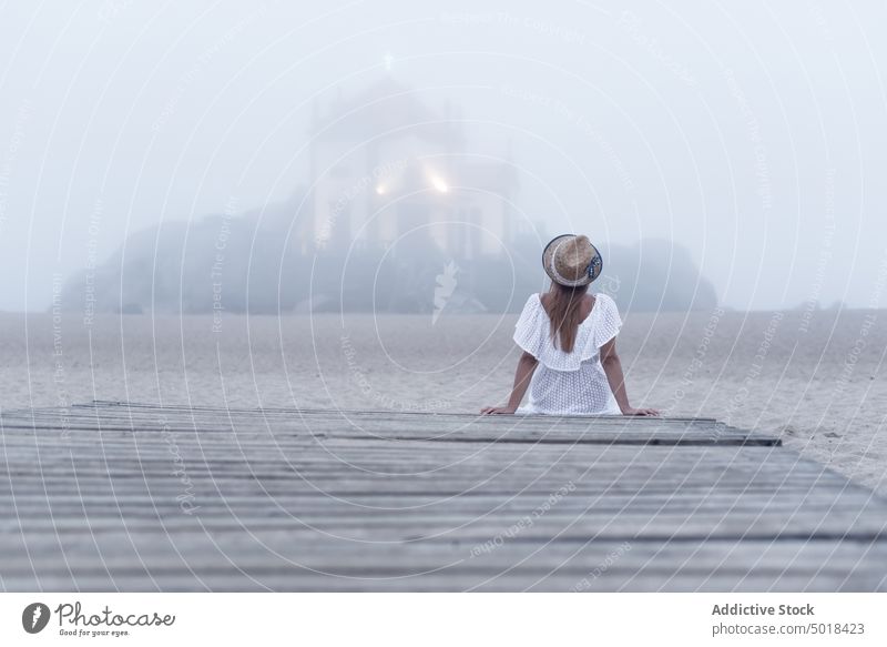 Anonymer Reisender, der vom Hafen aus den Altarraum und das Meer im Nebel betrachtet nachdenken Kirchenschiff Pier Urlaub Einsamkeit idyllisch Frau Dock ruhen