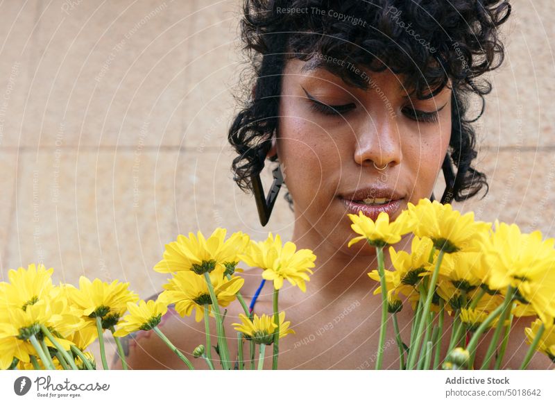 Tender ethnischen weiblichen in Sommerkleidung stehend mit Strauß leuchtend gelben Chrysanthemen Blumen auf der Straße Frau Blumenstrauß Haufen hell Blütezeit