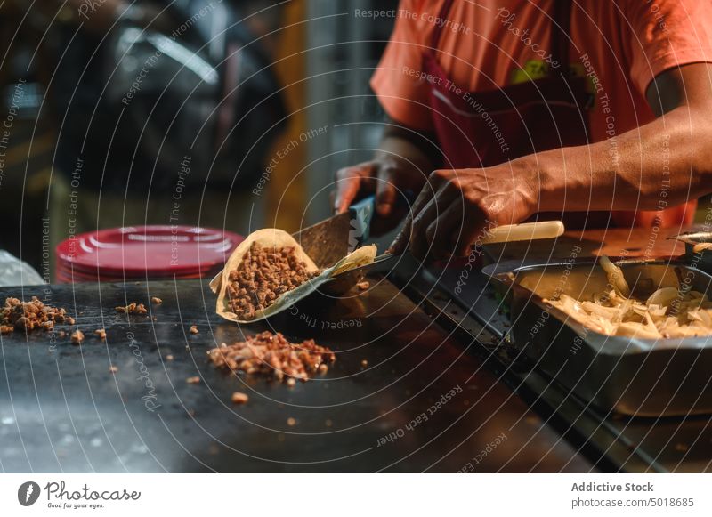 Ethnischer Koch bereitet leckere Tacos in der Restaurantküche zu Küchenchef vorbereiten Straßenessen mexikanisches Essen Mittagessen Abendessen Speise Mann