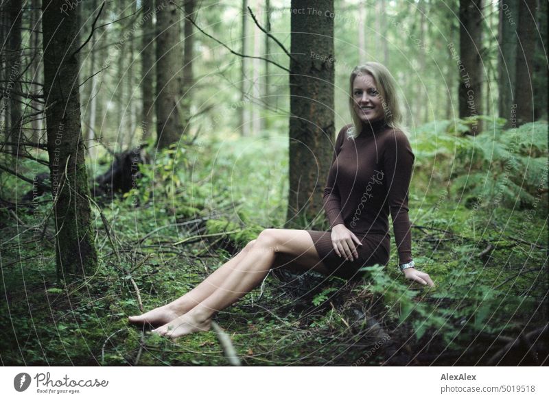 Junge, blonde Frau sitzt barfuß auf einem umgefallenen Baumstamm im Wald - analoges Kleinbild junge Frau feminin schön glücklich Jugendliche Portrait Erwachsene