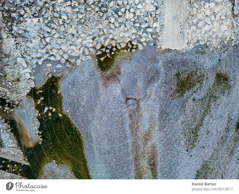 Der Grund des trockenen Flusses mit seinem Nebenfluss ist sichtbar. Über einen kleinen Wasserfall. Sichtbare Steine und Wasserreste. Luftaufnahme - Hintergrund