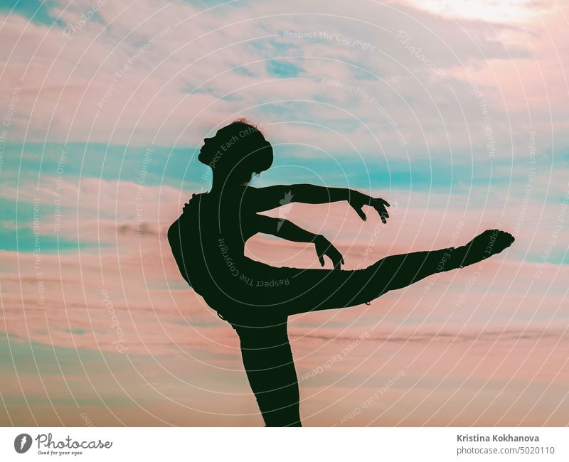 Silhouette der jungen Frau Ballerina oder Turner wie ein Vogel auf dramatischen Sonnenuntergang Himmel Hintergrund. Ballerina Übungen in eleganten Bewegungen. Konzept der Kunst, Natur Schönheit