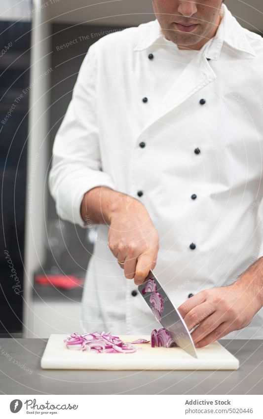 Profikoch schneidet Zwiebel Küchenchef Schneiden professionell Messer Schneidebrett Koch Mann Hand zerkleinernd Erwachsener Lebensmittel roh Gesundheit