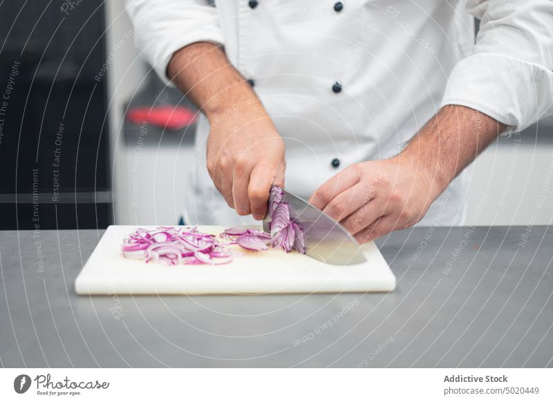 Profikoch schneidet Zwiebel Küchenchef Schneiden professionell Messer Schneidebrett Koch Mann Hand zerkleinernd Erwachsener Lebensmittel roh Gesundheit