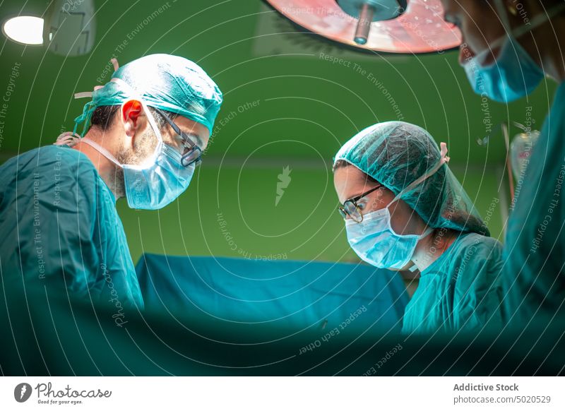 Mediziner, die Patienten operieren Arzt Chirurgie geduldig Assistent Operationssaal geschnitten Krankenhaus medizinisch Uniform professionell modern Mann Frau