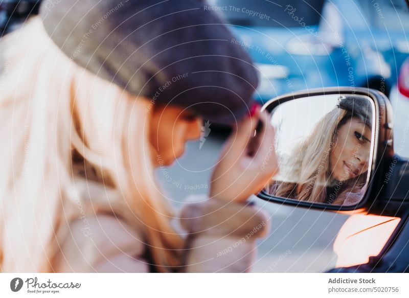 Ethnische Frau trägt Make-up in der Nähe des Autos auf Außenspiegel anwendend Wimperntusche Afroamerikaner jung Großstadt Straße PKW Reflexion & Spiegelung