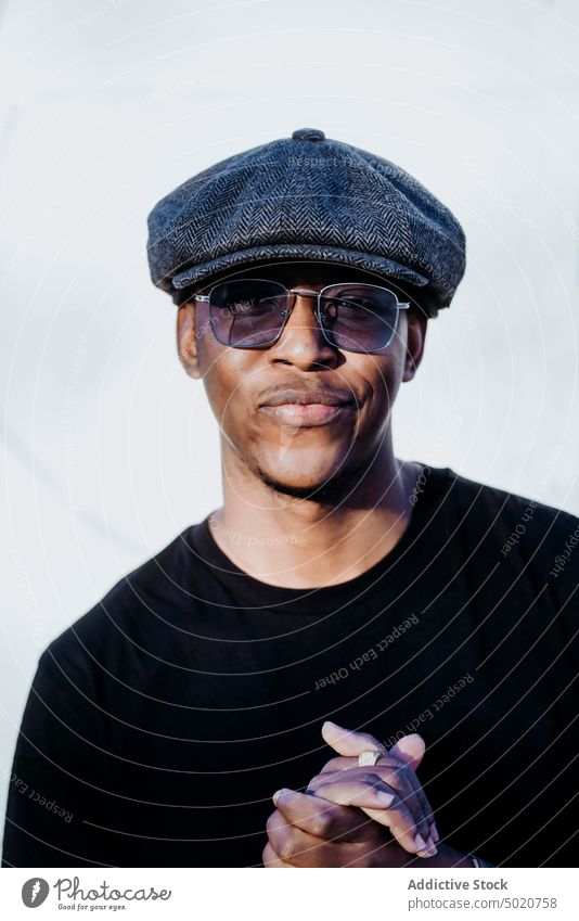 Stilvoller schwarzer Mann, der auf einer Straße in der Stadt wegschaut Afrikanisch Amerikaner Wand Großstadt Außenseite Mode männlich modern Zeitgenosse Hut