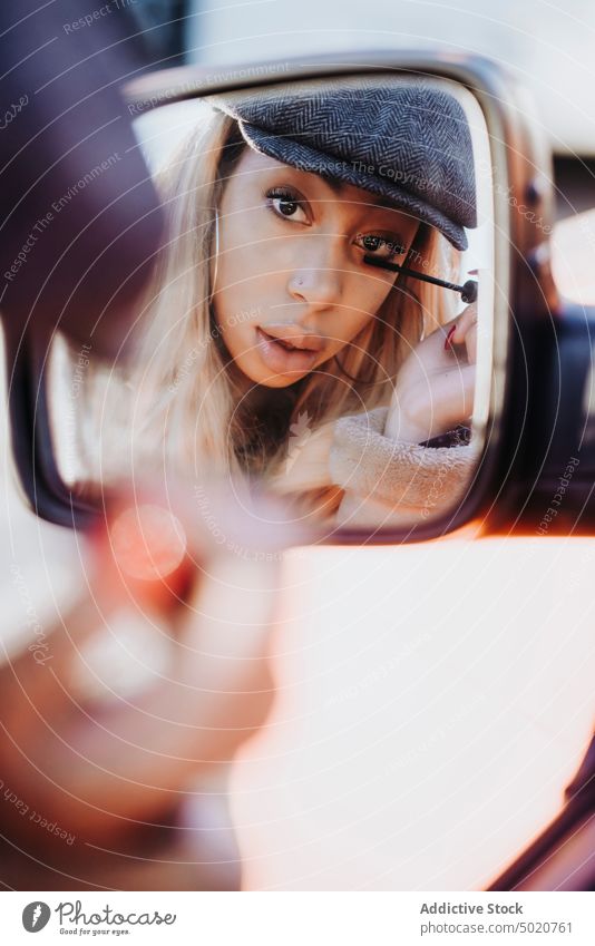 Ethnische Frau trägt Make-up in der Nähe des Autos auf Außenspiegel anwendend Wimperntusche Afroamerikaner jung Großstadt Straße PKW Reflexion & Spiegelung