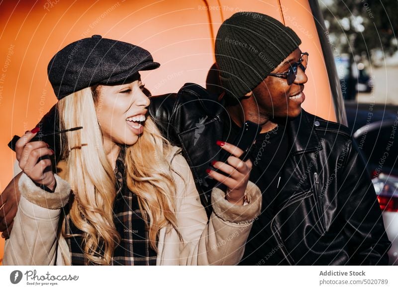 Schwarzer Mann, der eine lachende Frau mit Wimperntusche umarmt Freunde Straße umarmend schwarz heiter Make-up jung Afroamerikaner Ethnizität Glück Spaß urban