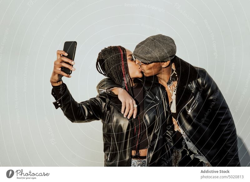 Schwarzes Paar, das sich küsst und ein Selfie macht Kuss Wand umarmend schwarz jung Straße Großstadt Smartphone Frau Mann Zusammensein Liebe Lifestyle Freizeit