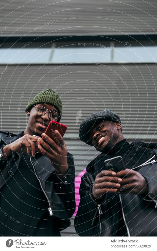 Schwarze Freunde benutzen Smartphones auf der Straße Mann benutzend Großstadt Zusammensein schwarz urban modern Mobile Telefon Männer Lifestyle Freizeit