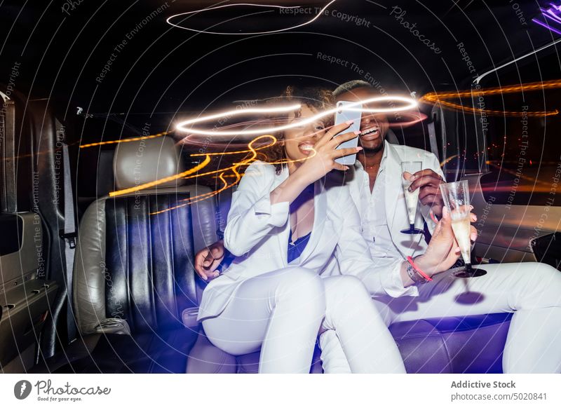 Afroamerikanisches Paar macht Selfie in Limousine Party Nachtleben Smartphone Champagne ausgefallen Zusammensein ethnisch Mitfahrgelegenheit Mann Frau