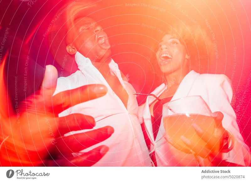 Schwarzes Paar schreit während einer Party Tanzen Nachtclub Rotlicht ethnisch Cocktail betrunken Spaß Mann Frau Alkohol Getränk trinken feiern festlich
