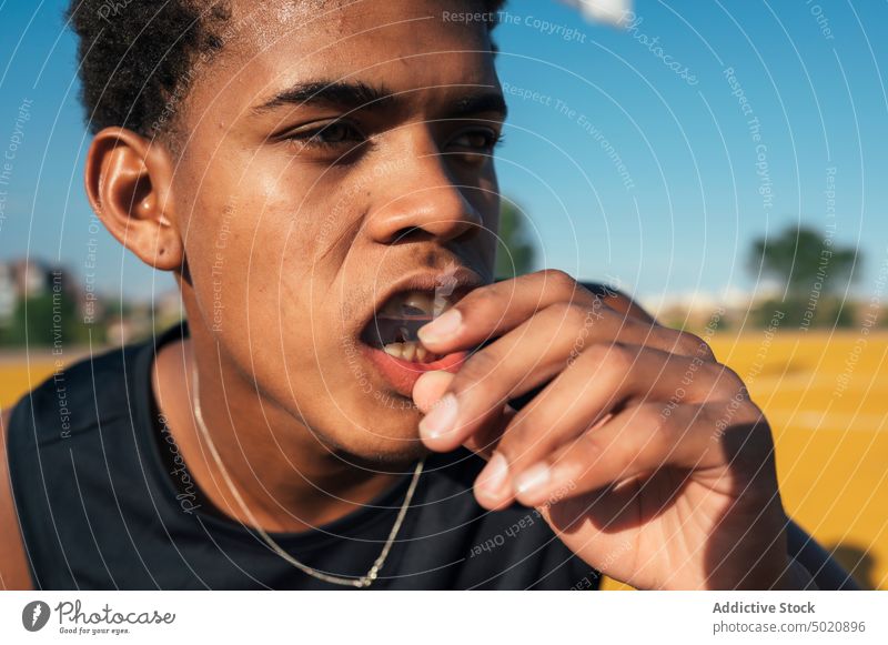 Schwarzer Sportler nimmt Mundschutz in den Mund Athlet Spieler Saison ernst Gerät Gesicht Schutz üben Uniform Jugend Aktivität sportlich Kopf Konkurrenz