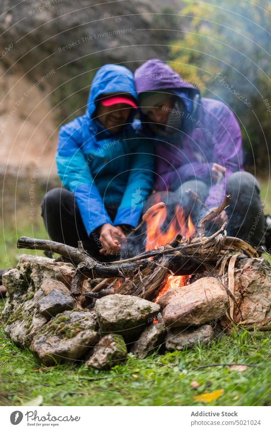Menschen in warmer Kleidung sitzen am Feuer und braten Würstchen Wurstwaren Fahrrad Flamme Abenteuer Zusammensein erwärmen Freundschaft aktiv schützend