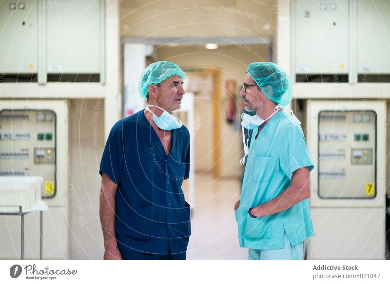 Zwei Chirurgen unterhalten sich im Krankenhaus sprechend Operationssaal Ärzte Klinik Gesundheitswesen Männer Team Uniform Medizin Spezialist Erwachsener
