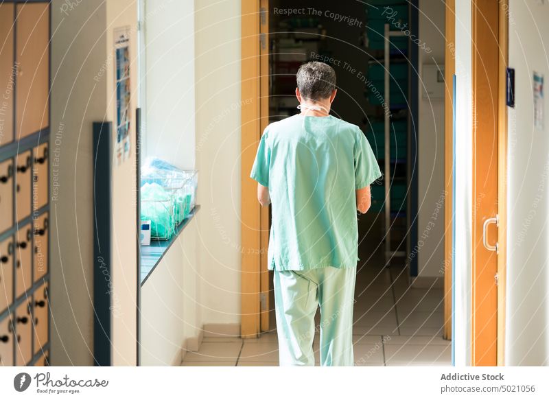 Chirurg mit Smartphone Krankenhaus laufen benutzend Gang Mann Erwachsener Arzt Medizin Gesundheitswesen Pause Uniform Technik & Technologie Gerät Apparatur