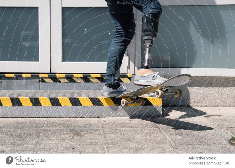 Skater mit Beinprothese springt auf der Straße Mann Skateboard springend Motivation Prothesen künstlich Trick Tatkraft Herausforderung Gebäude Großstadt Glied