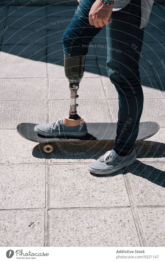 Mann mit Beinprothese fährt Skateboard Mitfahrgelegenheit künstlich Tatkraft Motivation dynamisch Wand Straße Amputierte Großstadt Außenseite jung Beton Energie