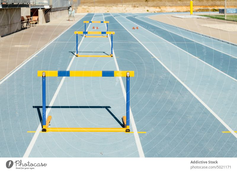 Bunte Hürden auf blauer Rennbahn Stadion Training Leichtathletik Sport Aktivität farbenfroh Gerät professionell Vitalität Wellness Barriere Kraft Hindernis üben