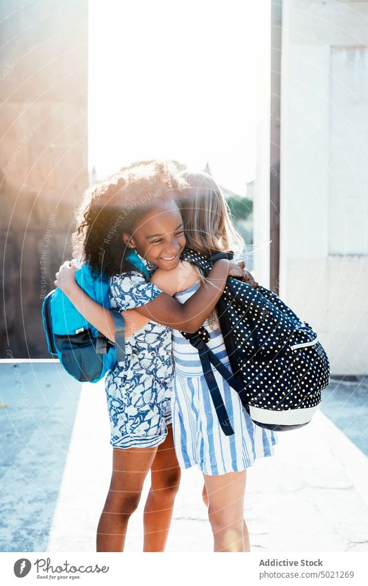 Multirassische freudige Mädchen umarmen sich im Sonnenlicht Umarmen bester Freund Bonden Glück Kinder multiethnisch Afroamerikaner Zusammensein Vielfalt