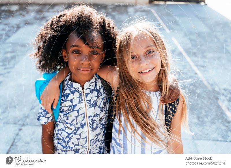 Multirassische freudige Mädchen umarmen sich im Sonnenlicht Umarmen bester Freund Bonden Glück Kinder multiethnisch Afroamerikaner Zusammensein Vielfalt