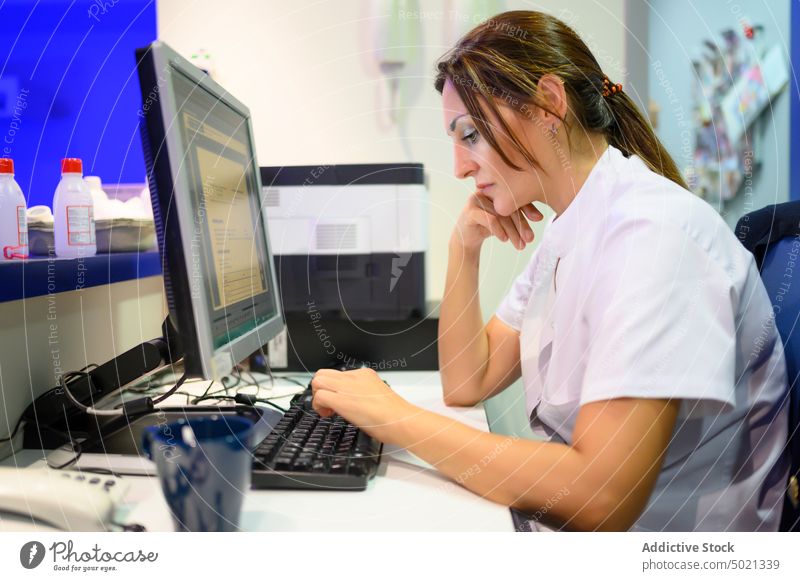 Müder Arzt am Computer im Krankenhaus benutzend müde Frau Arbeit Labor Uniform medizinisch Gesundheitswesen Erwachsener erschöpft Müdigkeit überarbeitet Beruf