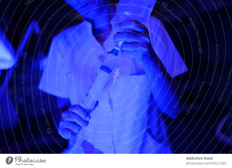 Weiblicher Arzt nimmt Medizin aus der Flasche neonatal Krankenhaus Station Arbeit Spritze Brutkasten Frau Nacht Illumination blau Umschalttaste Medikament