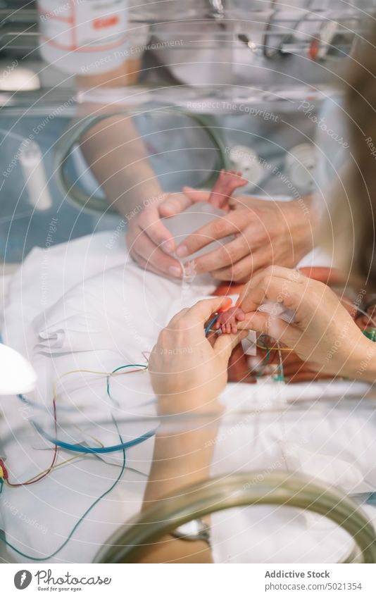 Arzt wärmt die Ferse des Neugeborenen im Inkubator neugeboren Brutkasten Erwärmung medizinisch Kinderärztin Baby Blutprobe Krankenhaus Behandlung Neonatologe