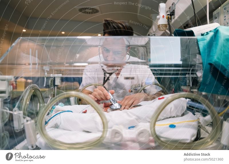 Arzt hört neugeborenes Baby im Inkubator ab hören Brutkasten medizinisch Kinderärztin Krankenhaus Behandlung Neonatologe Pflege Mann unschuldig Gesundheitswesen