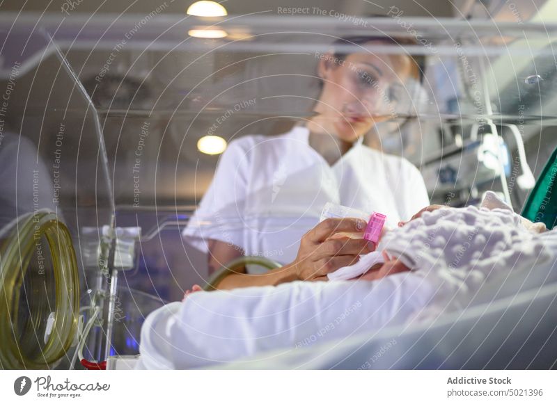 Krankenschwester füttert Baby im Inkubator Brutkasten Krankenhaus Futter Krankenpfleger Pflege verfrüht Arbeit medizinisch Säugling Behandlung Therapie geduldig