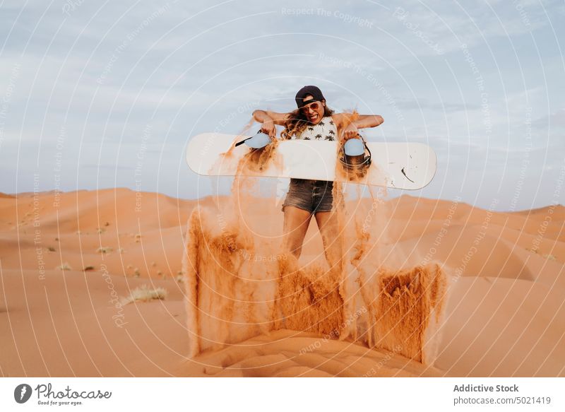 Junge Frau auf Sand stehend, bereit zum Sandboarding bedeckt Sport extrem Heben wüst Lifestyle Freizeit Urlaub reisen Feiertag Tourismus trocknen Düne Genuss