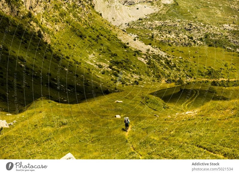 Anonymer Mann, der auf einem grasbewachsenen Weg in den Bergen spazieren geht Tourist Spaziergang Berge u. Gebirge Tal erkunden Natur Landschaft Kamm Hochland