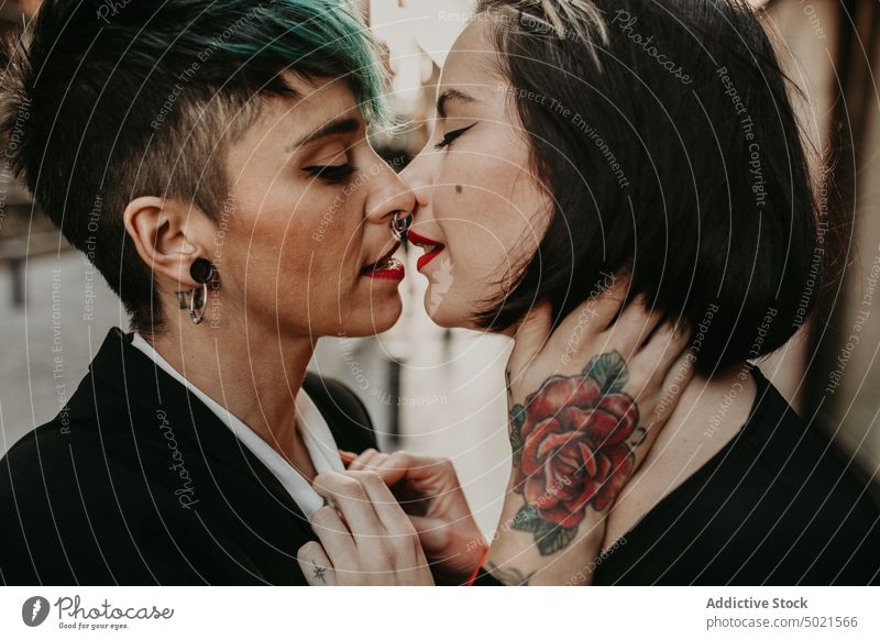 Junge stilvolle Damen küssen auf der Straße lesbisch Paar Küssen Piercing stylisch Tattoo Liebe jung romantisch Partnerschaft Frau Erwachsener Freundin