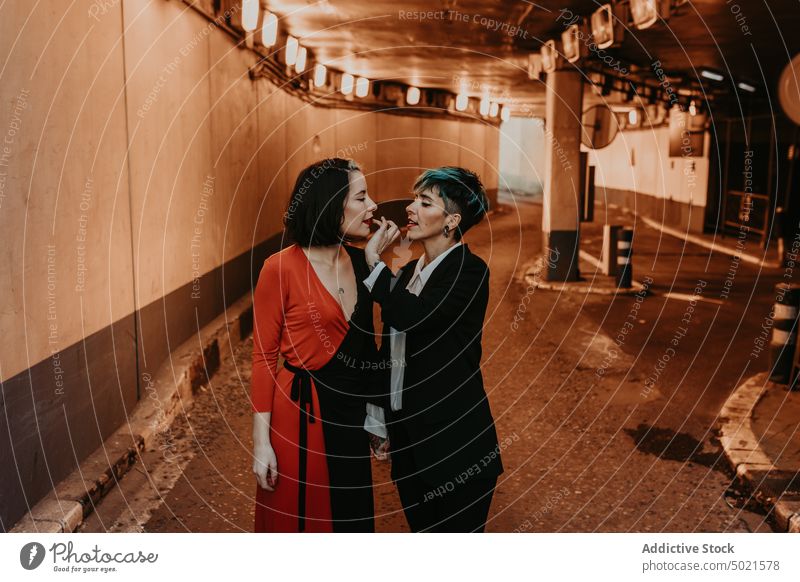 Junge Frauen in einem romantischen Moment im Tunnel lesbisch Paar Straße umarmend Küssen stylisch Tattoo Händchenhalten Liebe jung Laufsteg Stollen Glück heiter
